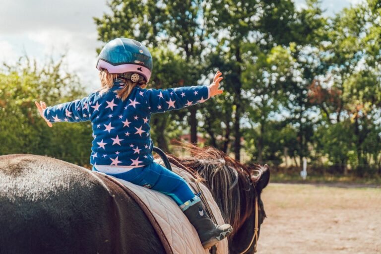 Enfant sur un poney les bras tendus
